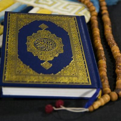 A close-up of the Holy Quran and prayer beads symbolizing Islamic faith and spirituality.